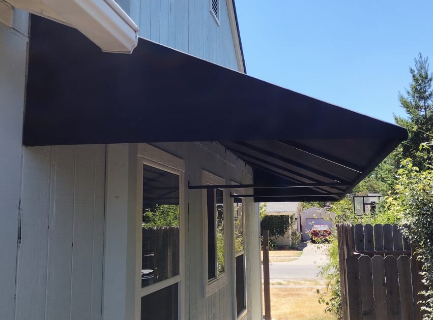 A black awning installed on a residential house, providing shade and enhancing the home's exterior appeal.